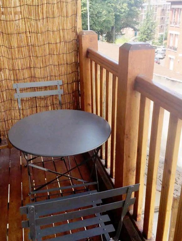 d'une table et d'un banc sur un balcon. dans l'établissement Appartement Charme petite terrasse à 400m de Paris, à Gentilly