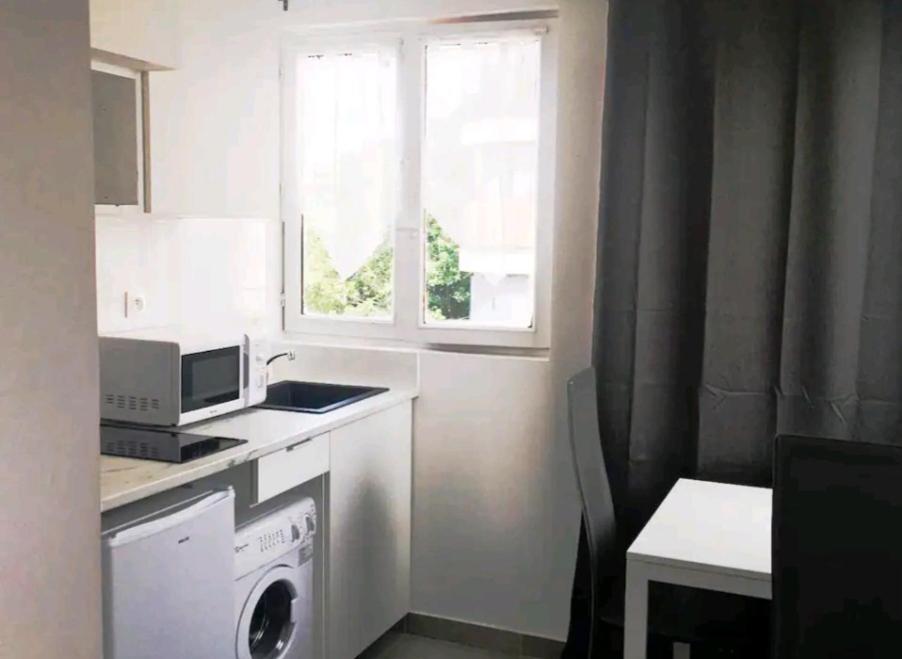 eine Küche mit Waschmaschine und Fenster in der Unterkunft Appartement Charme petite terrasse à 400m de Paris in Gentilly