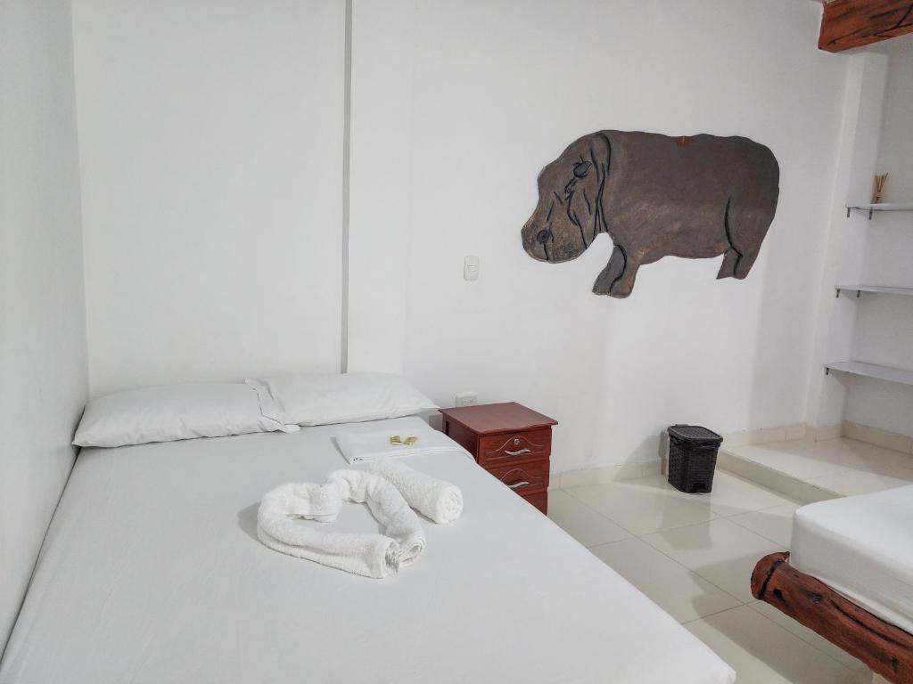 a bedroom with a bed with a bear on the wall at HOTEL EL EMPERADOR in Doradal