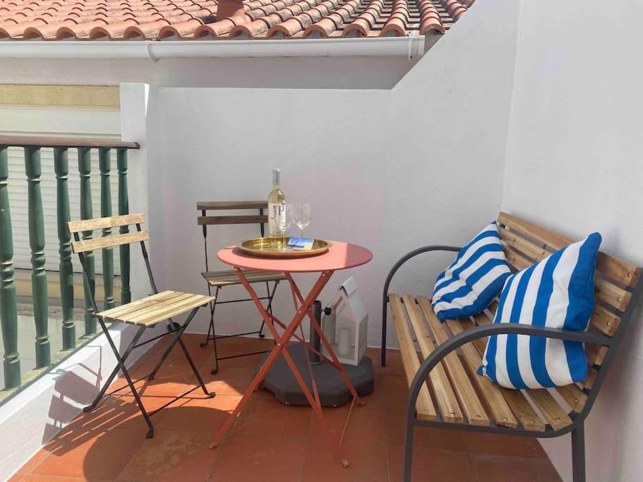 uma pequena mesa e cadeiras numa varanda com uma mesa e um tablet em The Captain’s House - 2min walking from the beach em Sesimbra