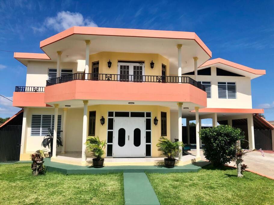 une grande maison avec une décoration rose dans l'établissement Caribbean Sunshine Villa, à Aguadilla