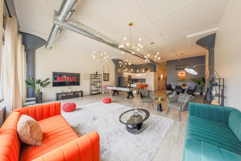 a living room with an orange couch and blue chairs at Slumber Stay - McCormick in Chicago