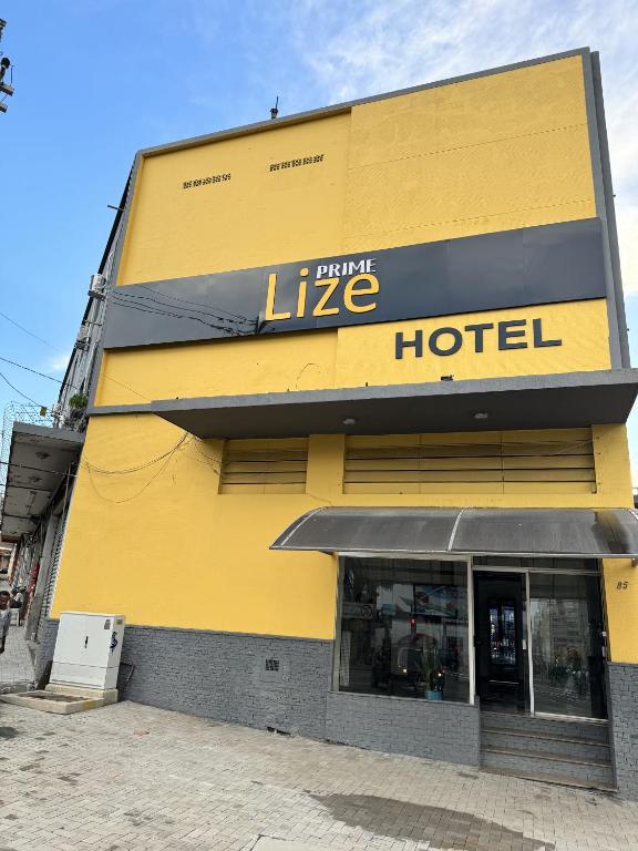 a large yellow building with a hotel on the side at Lize Prime Hotel in Campinas