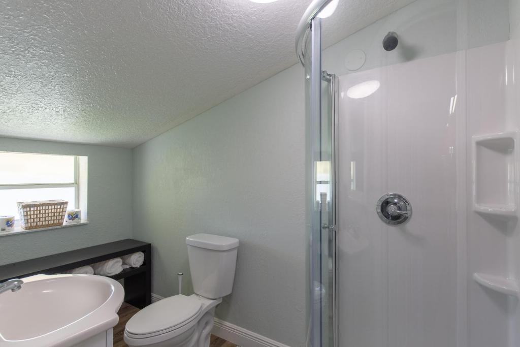 a bathroom with a toilet and a sink and a shower at Lake Side Loft Appt in Loxahatchee