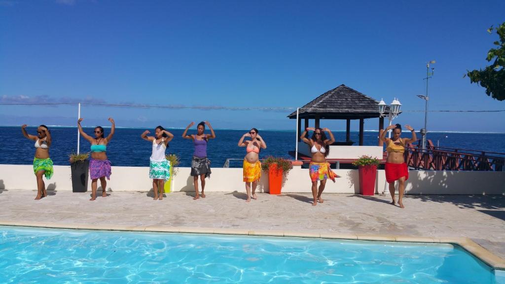 a group of people standing next to a swimming pool at Pension de famille HITI MOANA VILLA in Papara