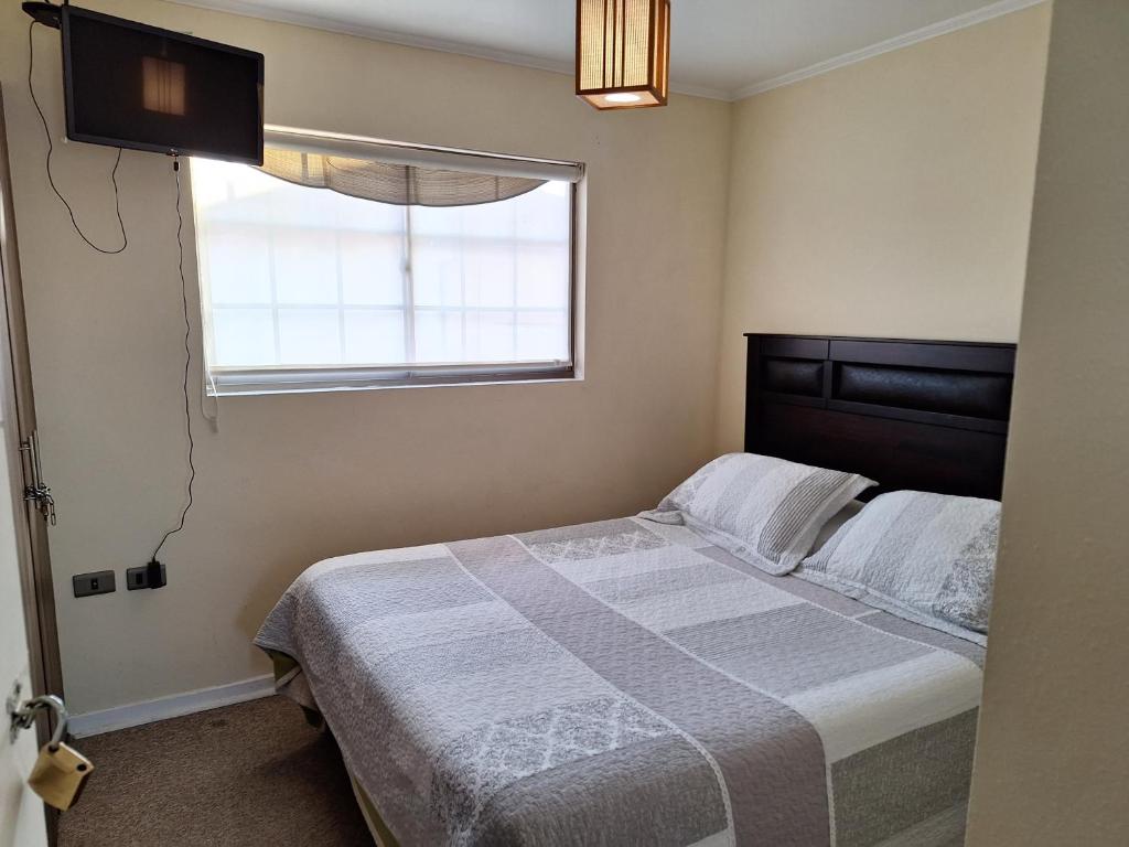 1 dormitorio con cama y ventana en Hospedaje casa Terracota en La Serena