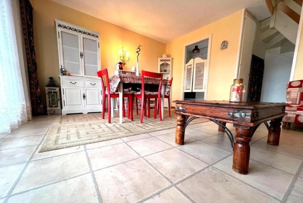 uma sala de estar com uma mesa e cadeiras vermelhas em Villars Soleil em Villars-sur-Ollon