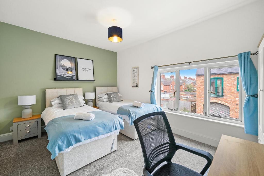 two beds in a room with a chair and a window at Spacious House - Sleeps 10 - Central Location - Free Parking, Fast WiFi and Smart TV with Nerflix by Yoko Property in Northampton