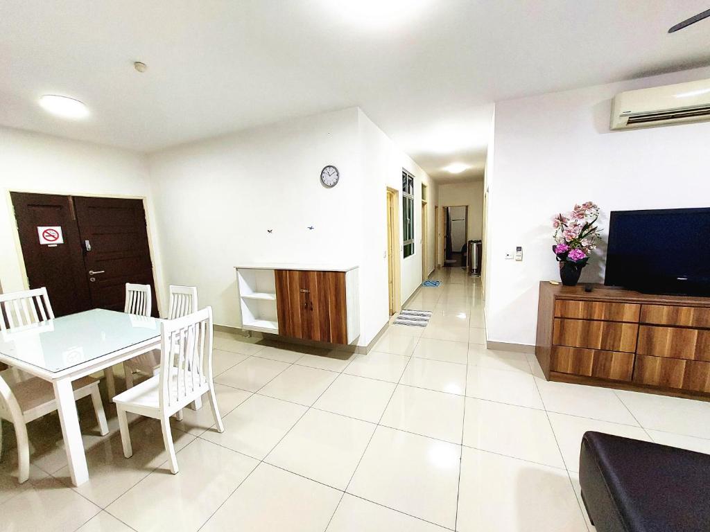 a kitchen and dining room with a table and a television at TuR15 PisaStadium 9pax 4rooms PrivateHouse in Bayan Lepas