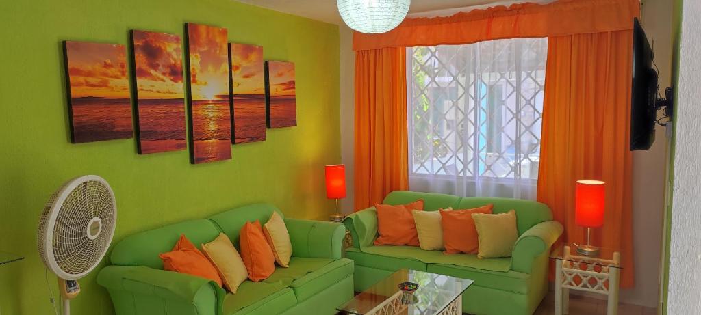 sala de estar con sofá verde y ventana en BONITA CASA EN BAHIA DE BANDERAS (BUCERIAS NAY), en Bucerías