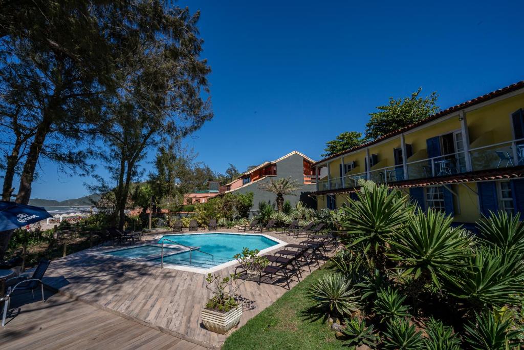 ein Resort mit einem Pool und einem Gebäude in der Unterkunft Pousada dos Gravatás in Búzios