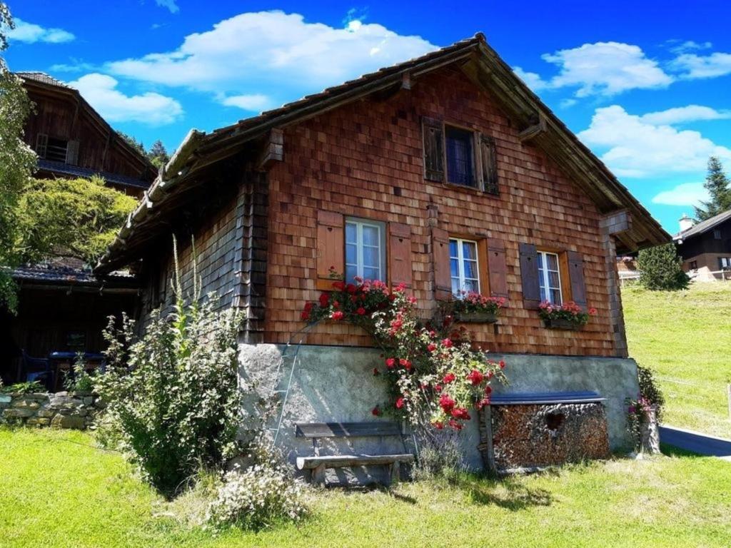 Alphütte Chilchschwand - b48558 في Stalden: منزل من الطوب عليه زهور