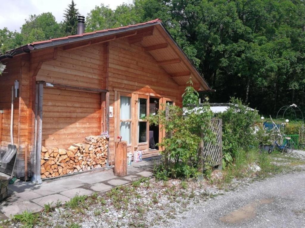 uma cabana de madeira com uma pilha de lenha em Chalet Blockhaus auf Camping - b48513 em Oberwil