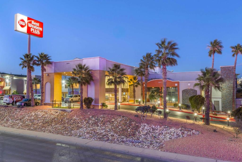 a building with palm trees in front of a street at Best Western Plus El Paso Airport Hotel & Conference Center in El Paso