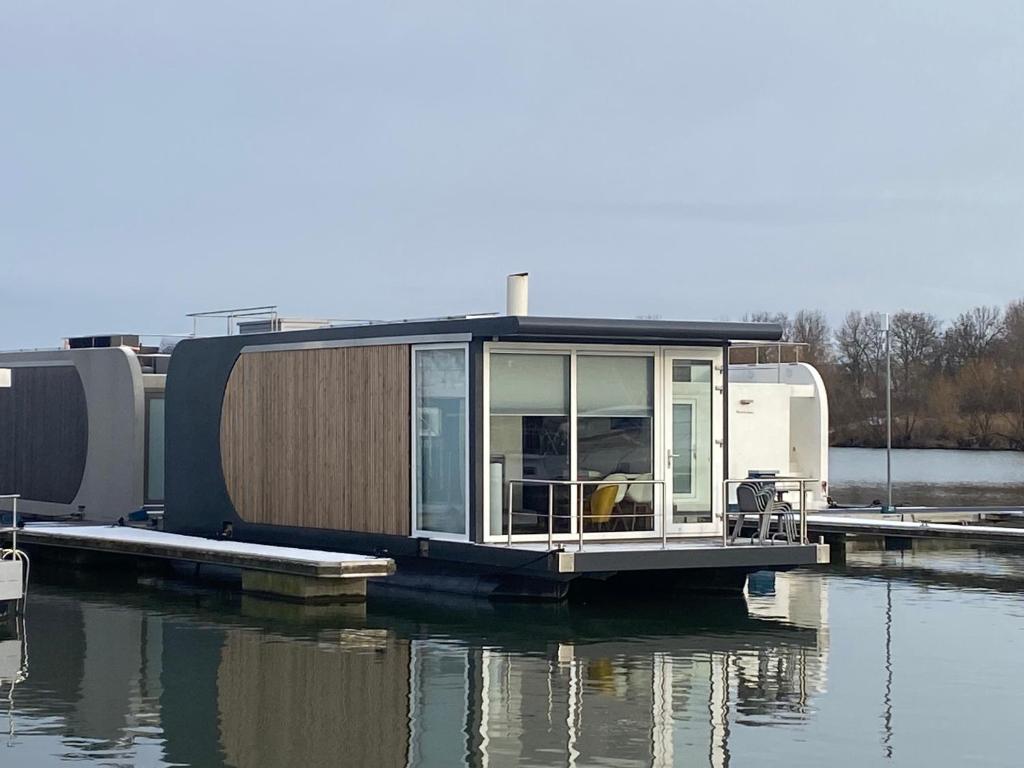 a tiny house on a dock in the water at Houseboat Trinidad in Maastricht