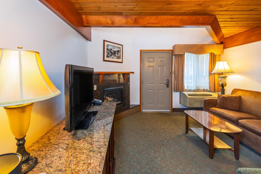 a living room with a television and a fireplace at Charltons Banff in Banff