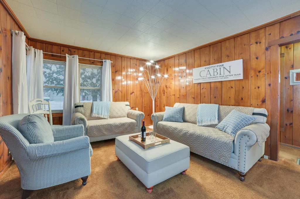 ein Wohnzimmer mit 2 Sofas und einem Tisch in der Unterkunft Dog-Friendly Roscommon Cabin, Walk to Higgins Lake in Roscommon