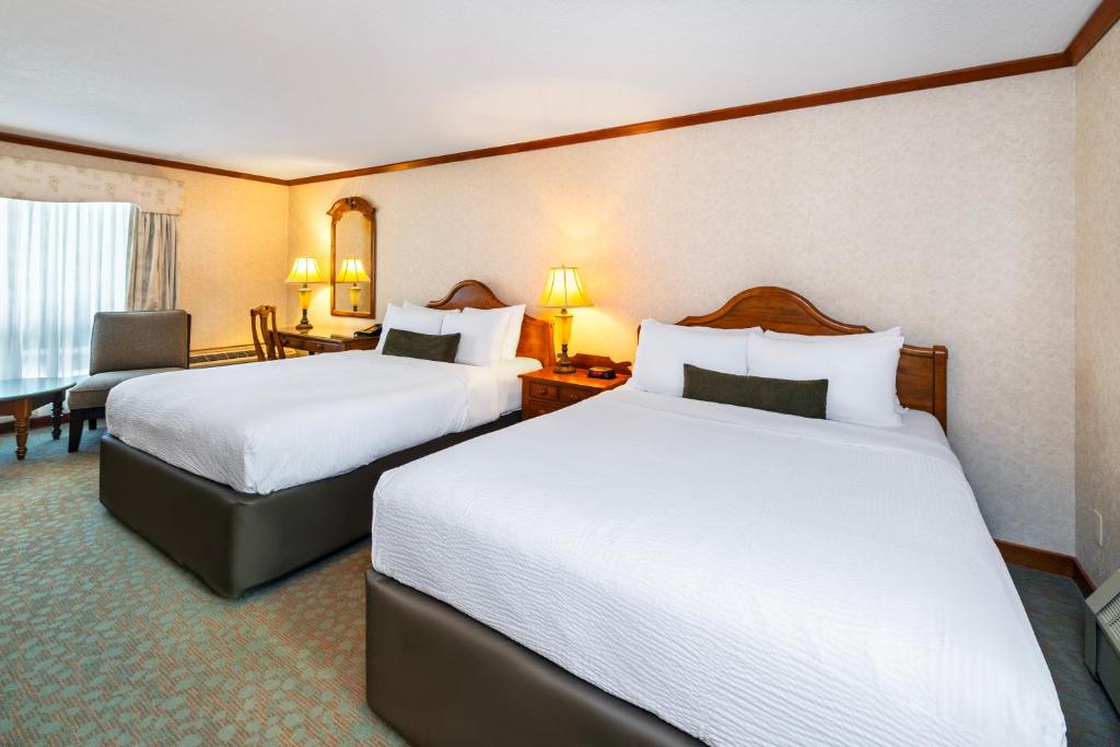 een hotelkamer met 2 bedden en een bureau bij Charltons Banff in Banff