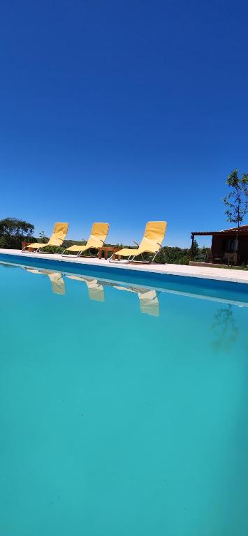 a row of chairs sitting in a swimming pool at Cabañas Potrero de Marquez Paraiso Adult only in Potrero de Garay