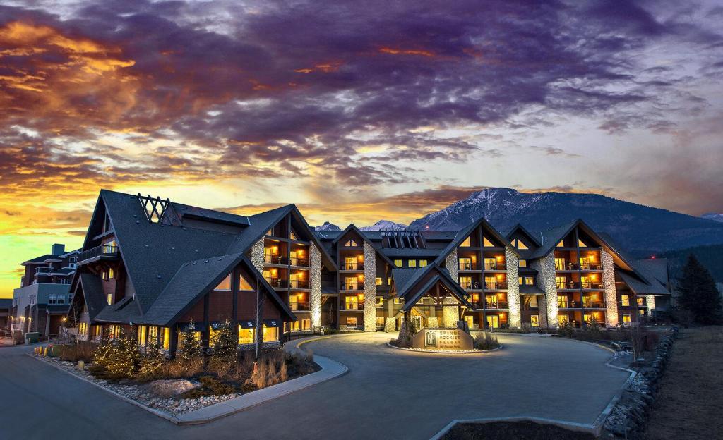 a large lodge with a mountain in the background at Sweet Condo Canmore GR：） in Canmore