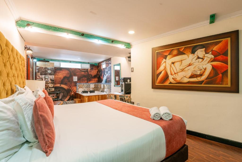 - une chambre avec un lit et une peinture murale dans l'établissement Hotel Casa Antigua, à Bogotá