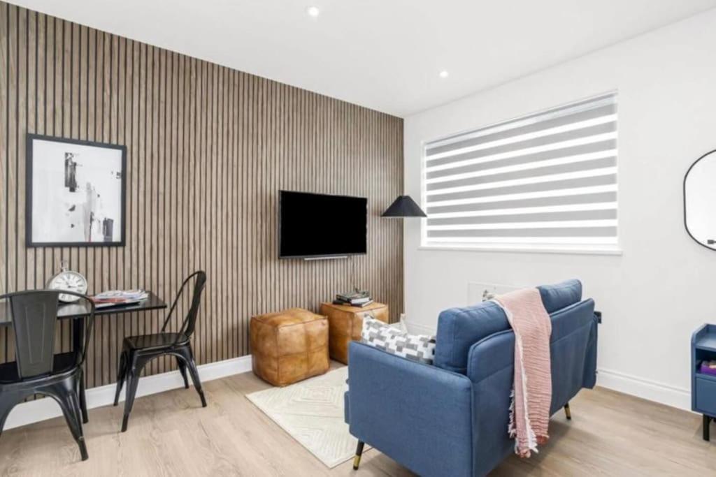 a living room with a blue couch and a table at Luxury Entire Apartment in Cowley