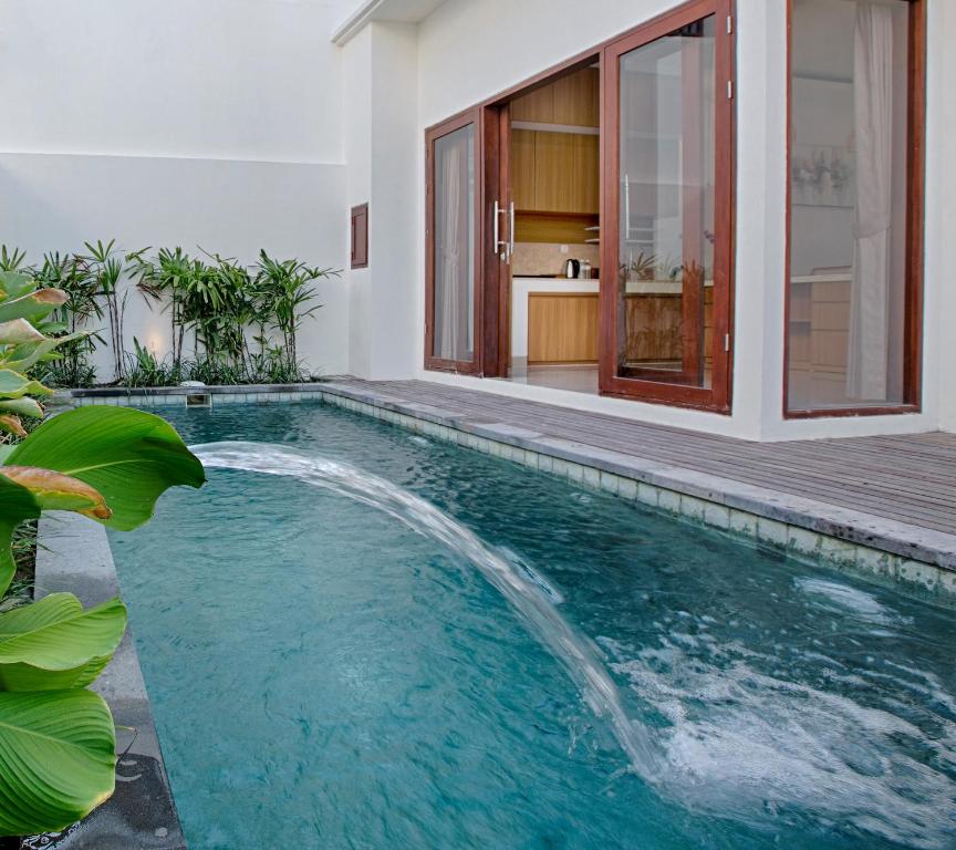 an indoor pool with a waterfall in a house at Taman Seminyak Suites in Seminyak