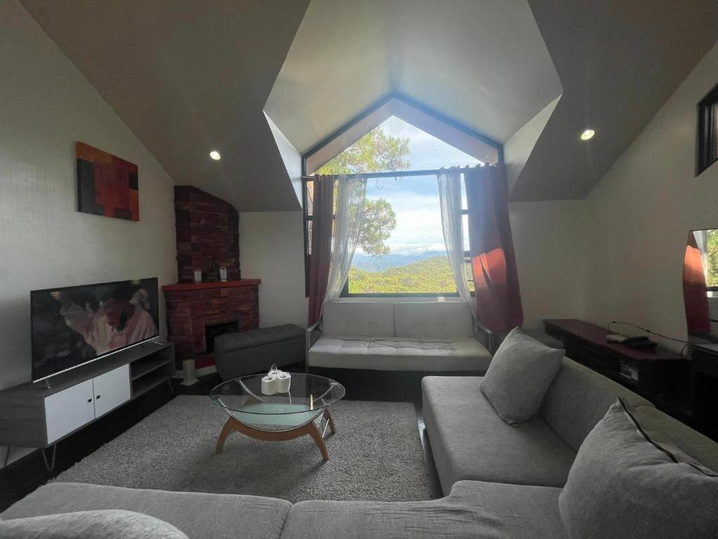 a living room with a couch and a window at Country Homes Sheridan Drive Camp John Hay Lot 16 in Baguio