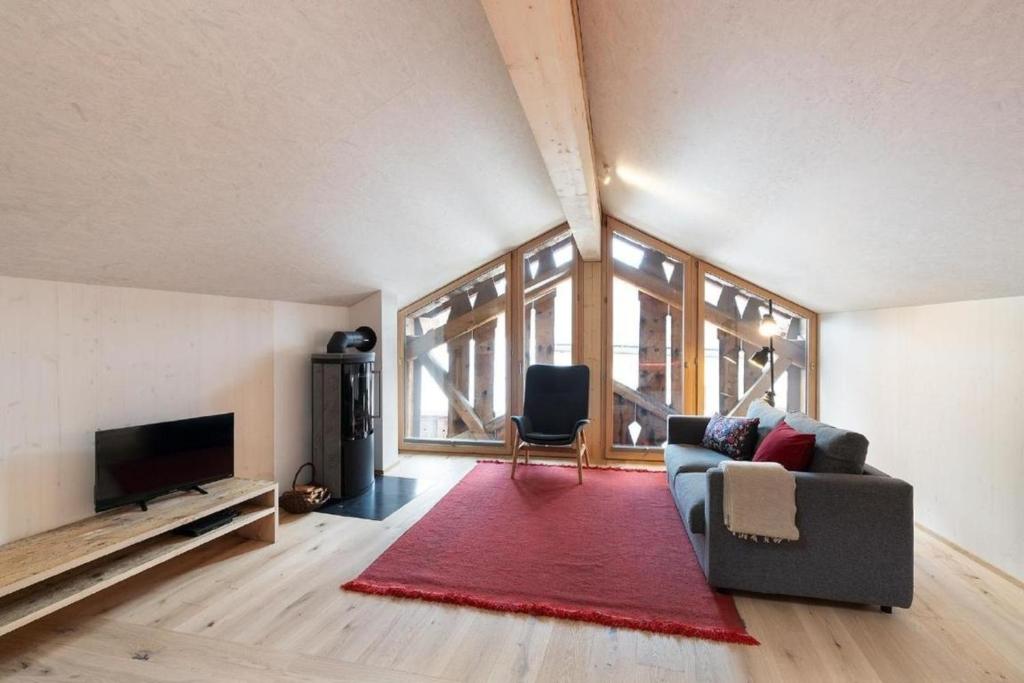 sala de estar con sofá y alfombra roja en Bijou - BioBergün - b48615, en Bergün