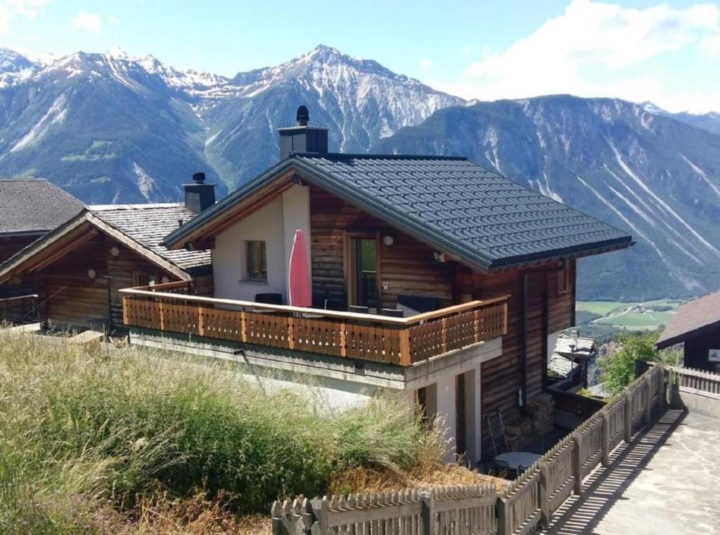 a house on a hill with mountains in the background at Chalet Angelika - b48583 in Albinen