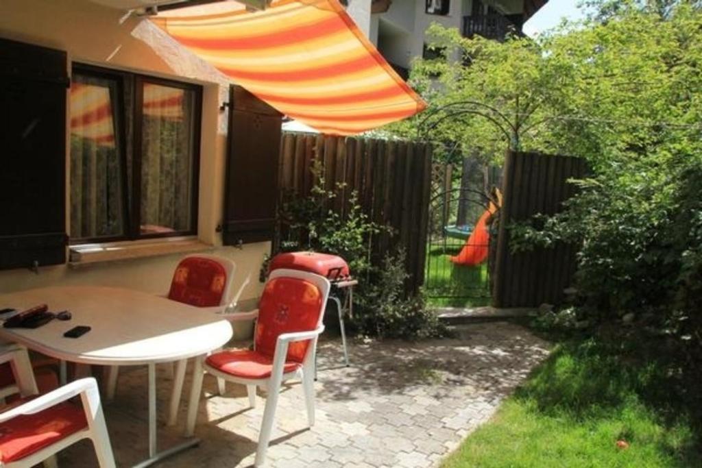 a patio with a table and chairs and an umbrella at 1 12 Zi Wohnung mit persönlichem Charme - b48574 in Vulpera
