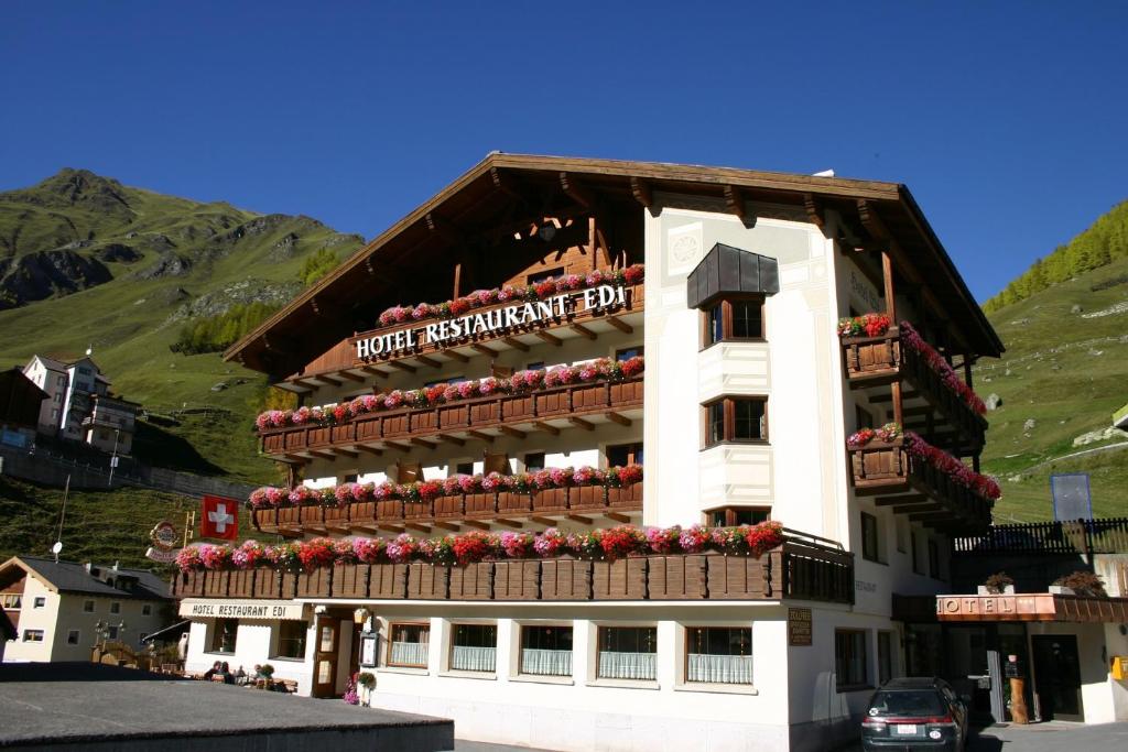 a building with a balcony with flowers on it at Hotel Edi in Samnaun