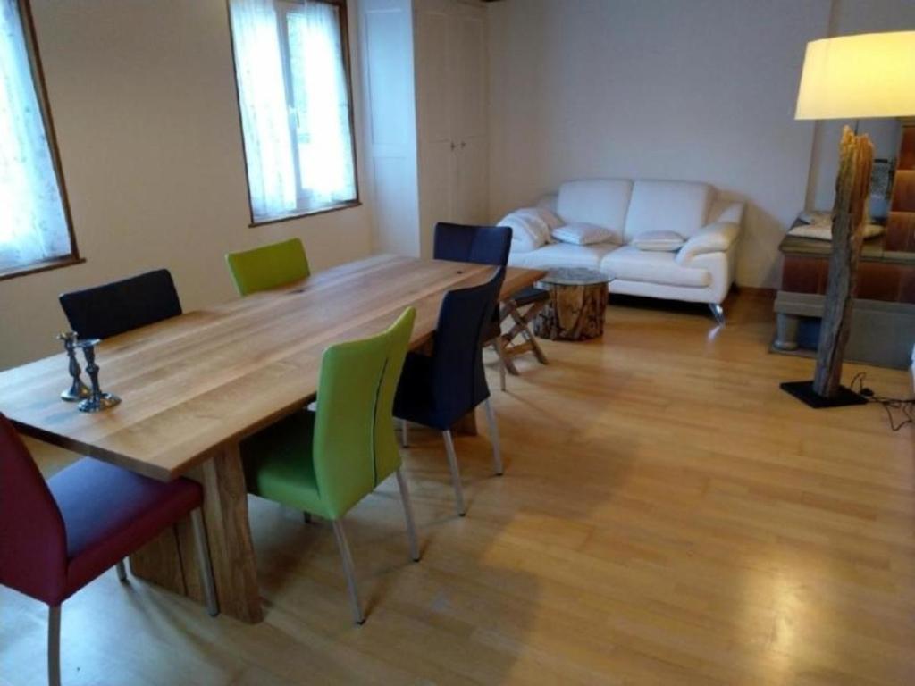 uma sala de estar com uma mesa de madeira e cadeiras em EmmeCottage - b48613 em Trubschachen
