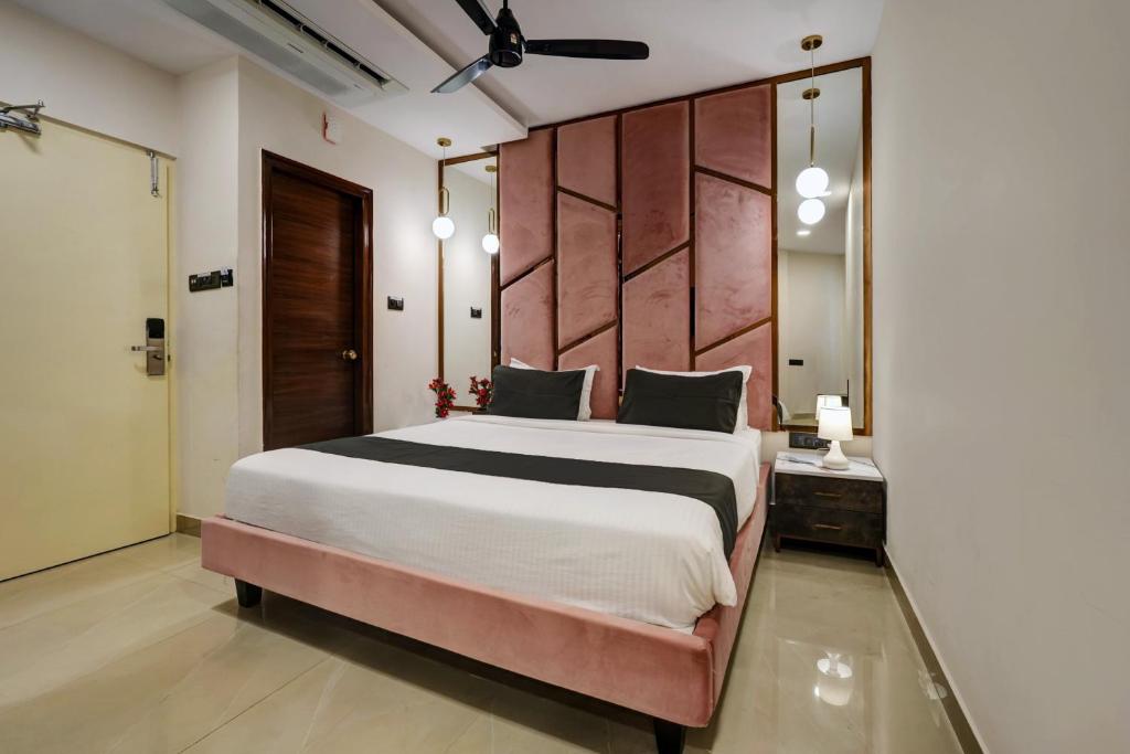 a bedroom with a large bed with a large headboard at Astra Hotels & Suites - Koramangala in Bangalore