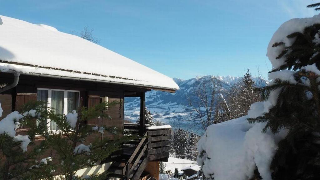 a snow covered cabin with a view of the mountains at Ferienhaus Luegisland - b48622 in Giswil