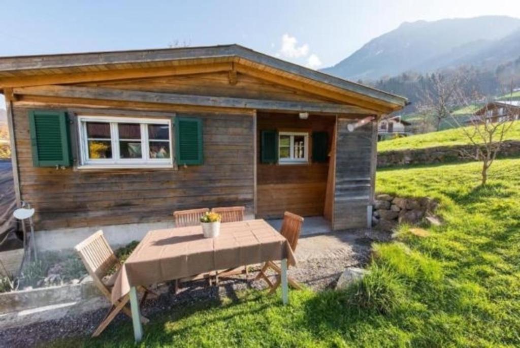 ein kleines Haus mit einem Tisch und Stühlen davor in der Unterkunft Bauernhof - Familienzimmer - b48580 in Lungern