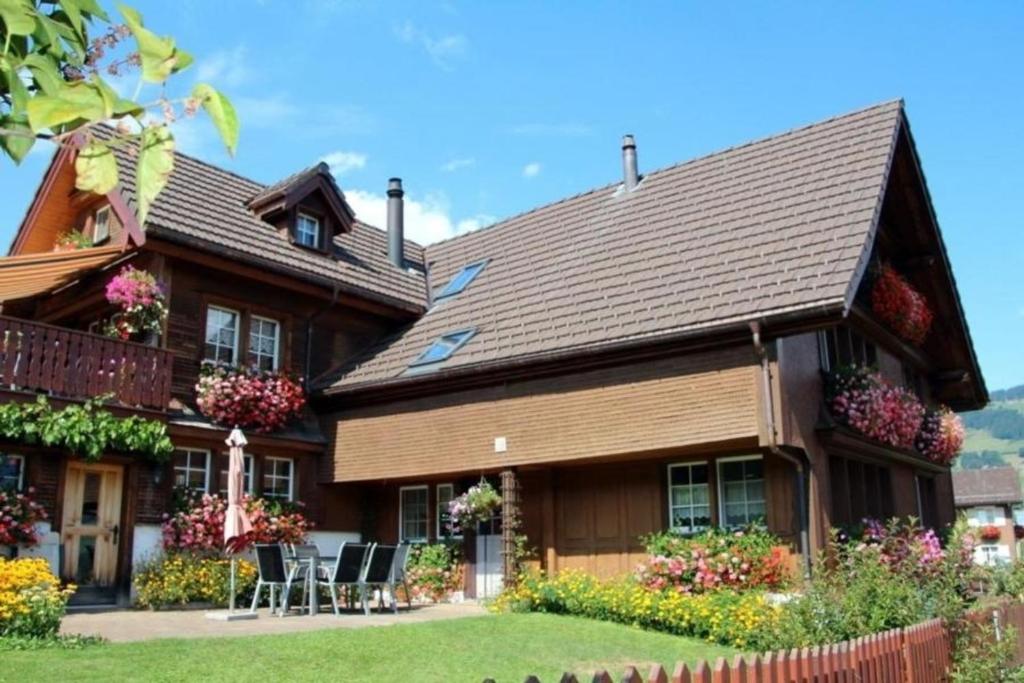 una casa con tetto a foglie d'azzardo con sedie in cortile di Gemütliche und geräumige Ferienwohnung - b48625 a Nesslau