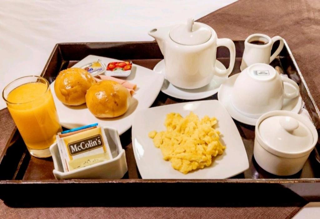 a tray of food with breakfast foods and a drink at D'eluxe Hotel Talara ubicado a 5 minutos del aeropuerto y a 8 minutos del Centro Civico in Talara