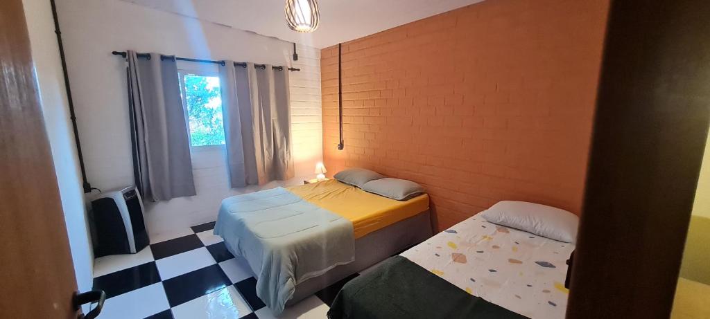 een kleine kamer met 2 bedden en een raam bij Breeze Floripa - Campeche in Florianópolis