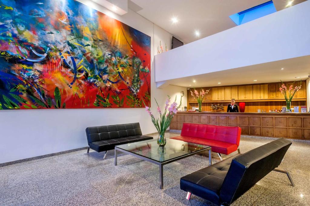 a lobby with two couches and a painting on the wall at Hotel Oceanía Bogotá in Bogotá