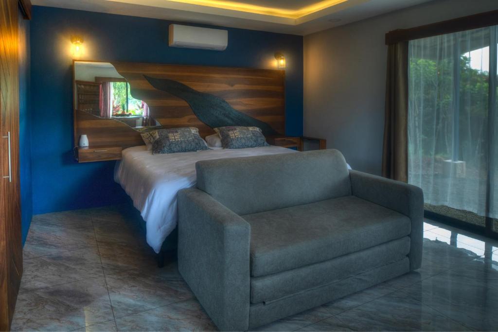 1 dormitorio con 1 cama y 1 silla en Conejo's Loft, River View, Full privacy and nature, en Fortuna