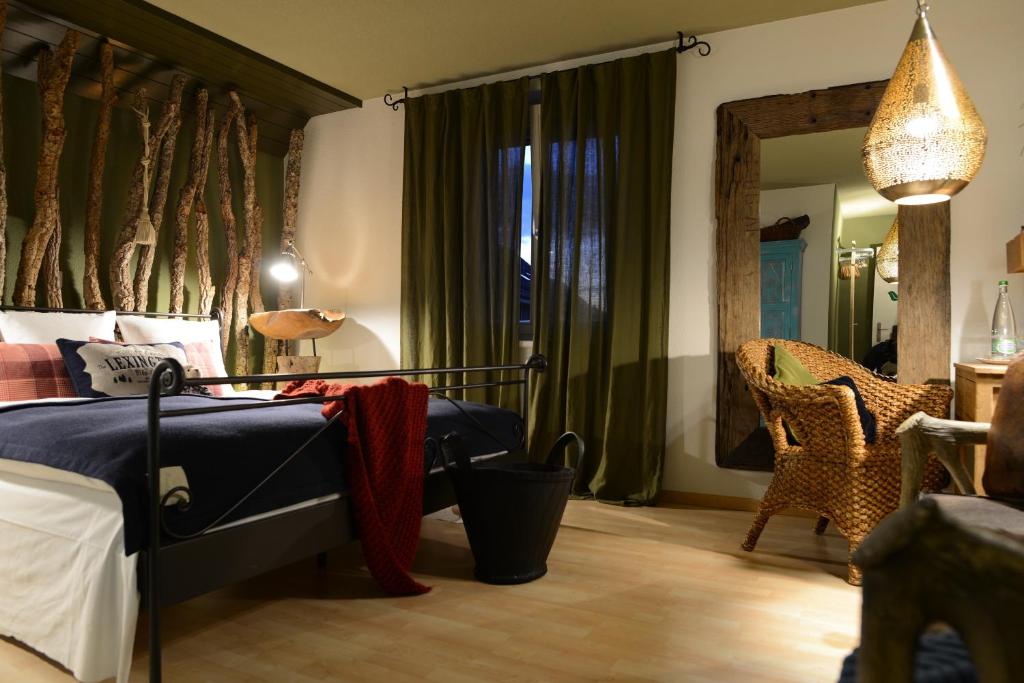 1 dormitorio con cama, silla y espejo en Gasthof zum Bären Birmenstorf GmbH, en Birmenstorf