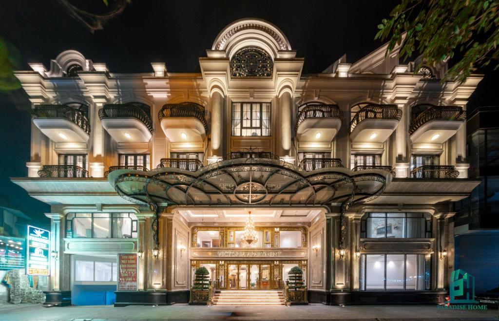 a large building with a lit up facade at night at Paradise Suites Trich Sai in Hanoi