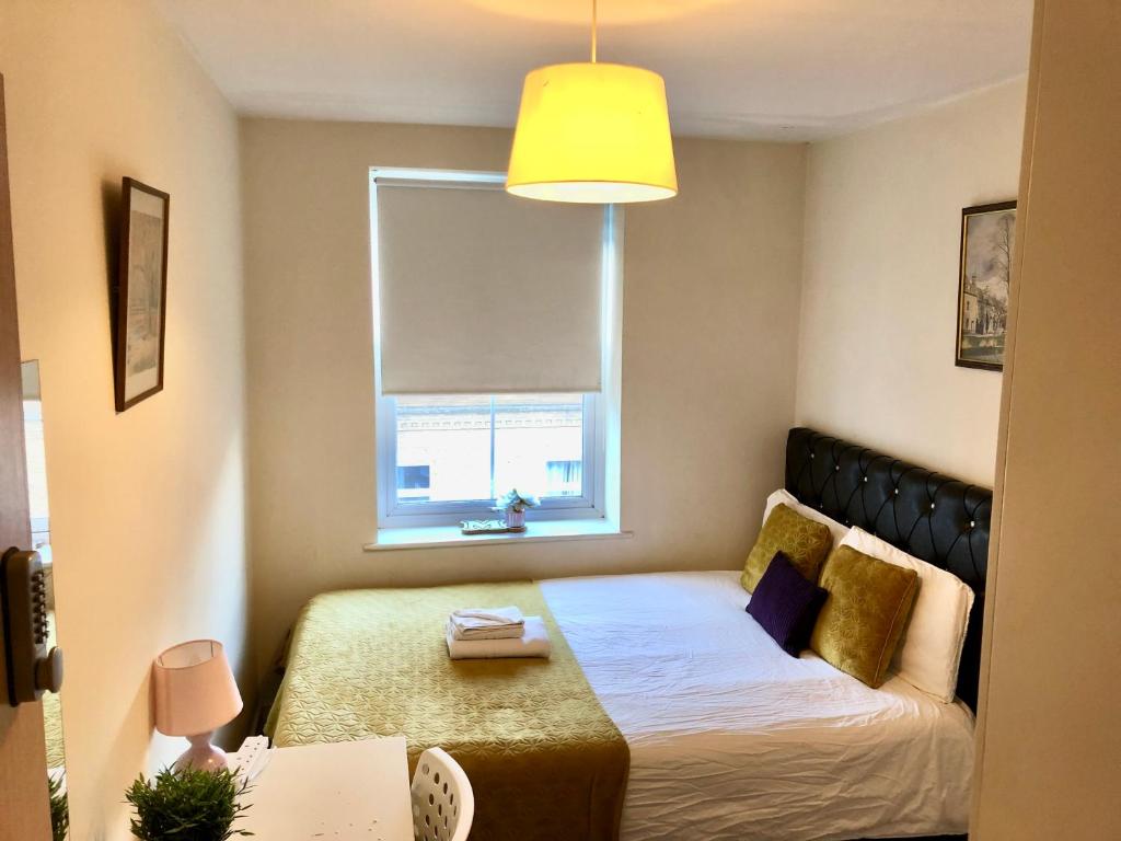 a small bedroom with a bed and a window at Metropolitan Coziness Private Bedrooms in Euston Station 161 in London