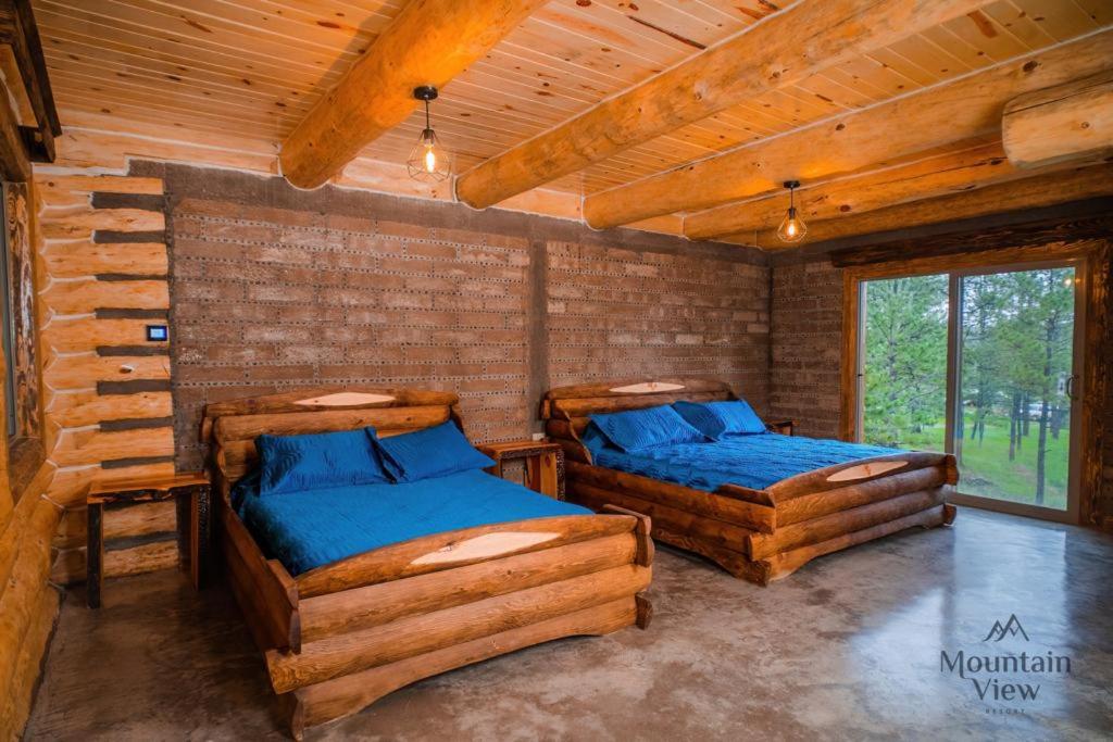 2 Betten in einem Zimmer in einem Blockhaus in der Unterkunft Mountain View Resort in Bajío Las Palmas
