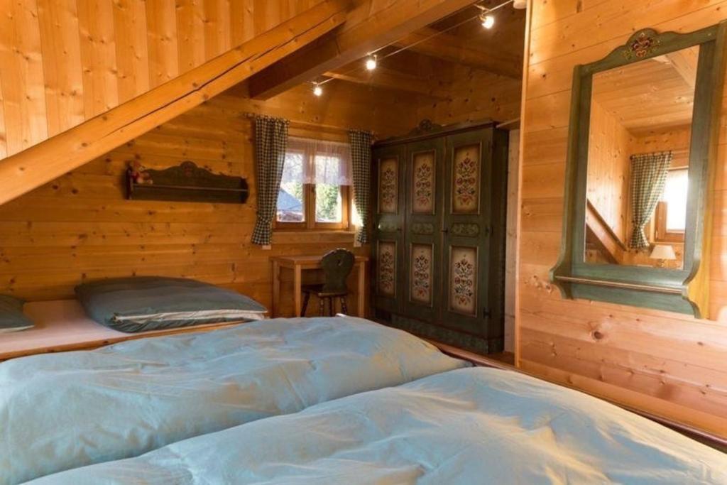 um quarto com uma cama num chalé de madeira em Almhüttenurlaub in Kärnten mit herrlicher Aussicht auf die Berge - b48725 em Klippitztorl