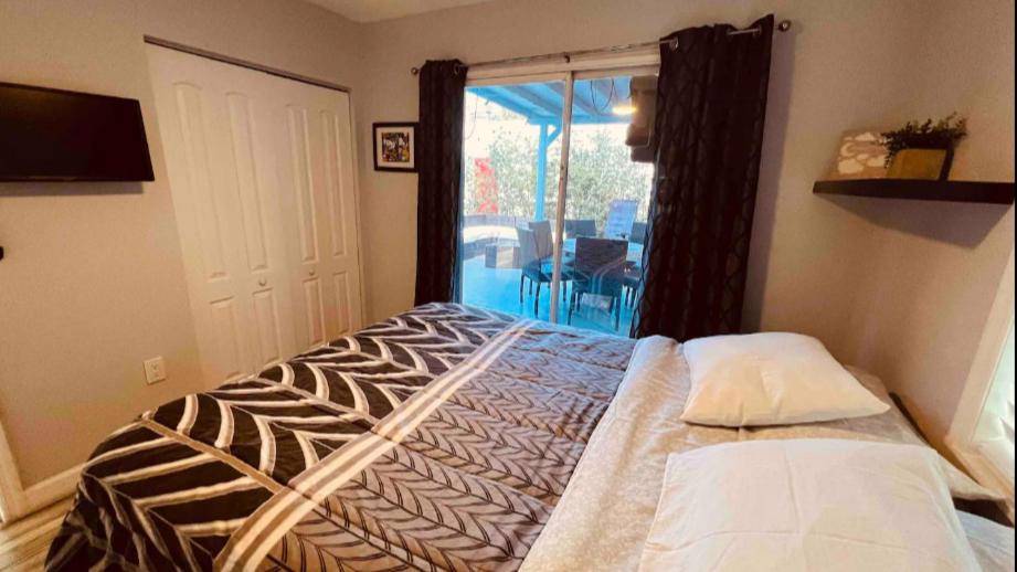 1 dormitorio con 1 cama y puerta que da a un patio en Keese's Cottages en Fort Lauderdale