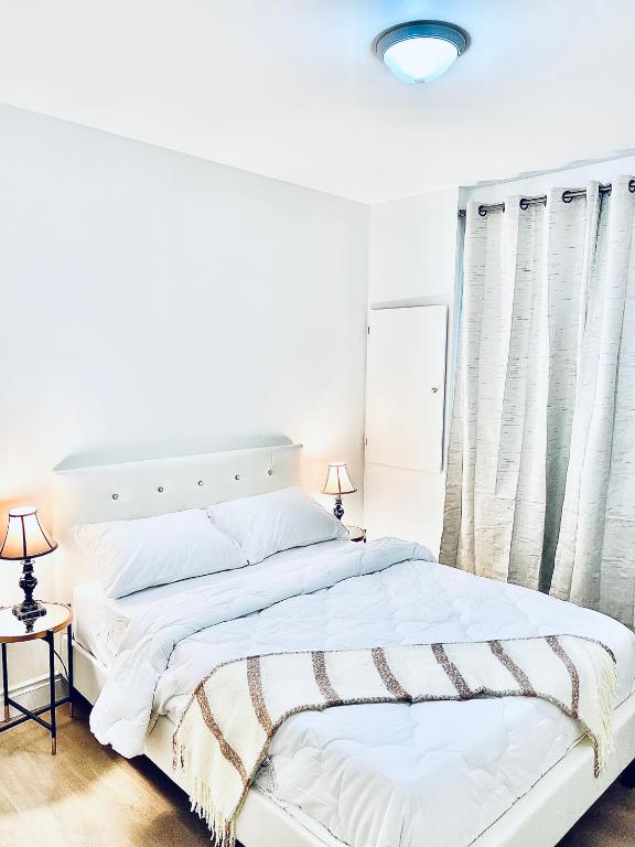 a white bedroom with a large bed and two lamps at LaVida Exclusive Guest House(Rm#4) in London