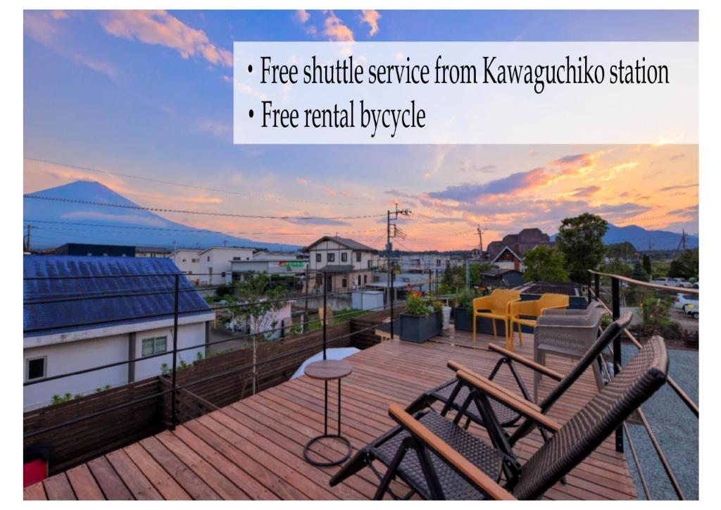 a balcony with two chairs and a view of a city at CAMP＆COTTAGE THE DOOR in Fujikawaguchiko