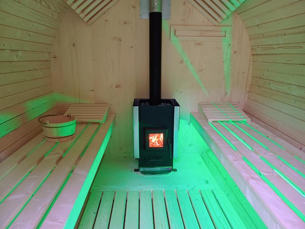 a wood stove in a sauna with green and pink lights at Pensiunea Lory in Piatra Neamţ